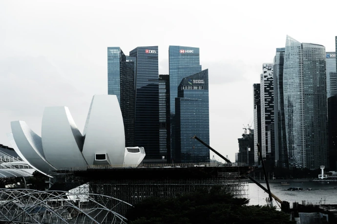 Modern buildings and a unique waterfront structure in singapore.